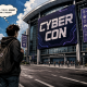 A person looks at a large conference center with a cyber con banner